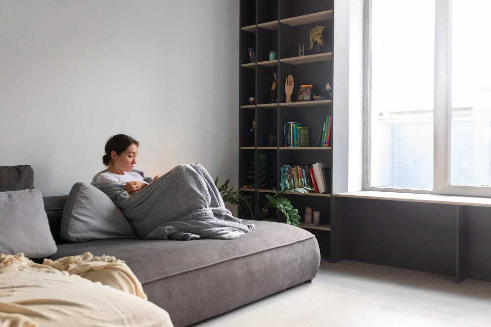 A serene bedroom with a bookshelf and reading chair instead of a television