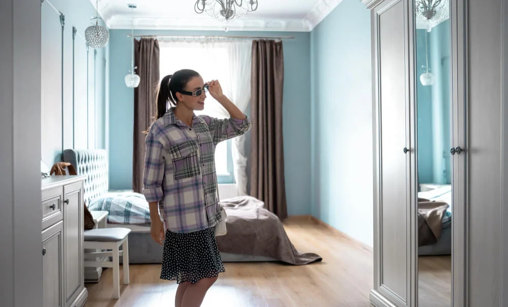 A standing mirror angled towards a corner rather than facing the bed directly